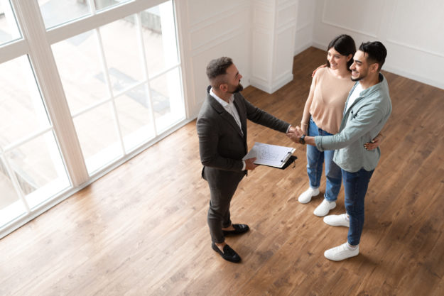 Couple Buying New Apartment, Shaking Hands With Realtor